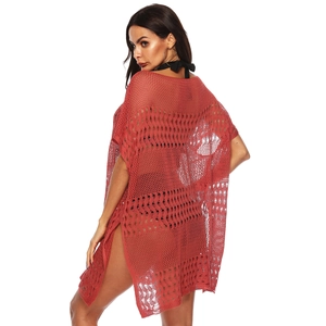 Détail de la texture en maille crochetée et fente latérale sur la robe de plage orange