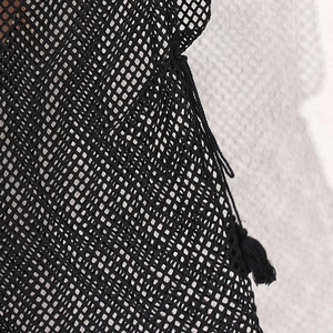 Detailed macro view of black mesh fabric texture featuring delicate tassel fringe edges