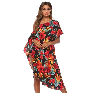 Détail de l'imprimé floral tropical sur une robe de plage noire à épaules dénudées