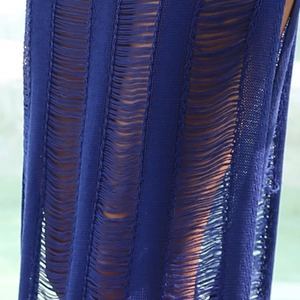 Détail macro du tricot bleu foncé avec motifs ajourés et texture rayée pour jupe de plage