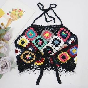 Detail of colorful crochet boho top featuring granny squares and pearl fringe trim