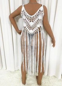 Detail of white crochet beach cover-up with fringe hem and geometric knit patterns