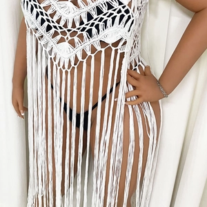 Detail view of white crochet cover-up showing geometric knit patterns and long tassels