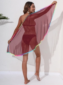 Détail du paréo de plage en maille rouge foncé avec des franges à pompons multicolores