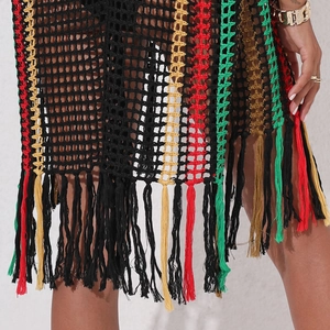Detail of crochet beach cover-up with rasta color stripes and long tassel fringe hem