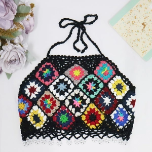 Detail of crochet halter top featuring colorful granny squares and pearl bead accents