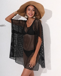 Detail of a black mesh beach cover-up with V-neckline and elegant tassel earrings