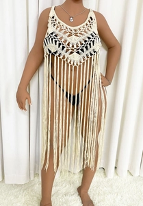 Detail of cream crochet knit beach cover-up with hollow patterns and long tassels