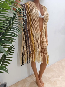 Detail of bohemian crochet beach cover-up featuring colorful stripes and long fringe hem