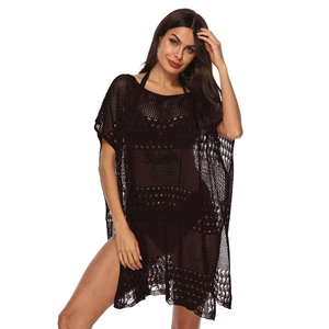 Détail de la robe de plage crochetée noire avec maille ajourée et motifs floraux complexes