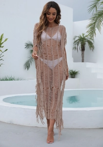 Détail d'une robe de plage en crochet marron clair avec maille filet et longues franges