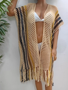 Detailed close-up of handmade crochet beach cover-up featuring colorful stripes and fringe hem