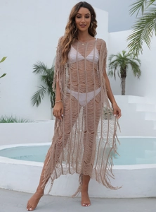Détail d'un cache-maillot au crochet kaki avec motifs en tricot et pompons fluides