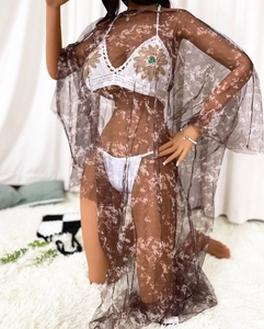 Détail du haut de bikini au crochet avec applique tournesol et paréo en maille