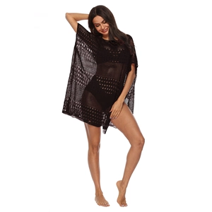 Détail macro de la texture en maille crochet noire de cette robe de plage bohème chic