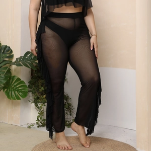 Detail view of sheer mesh beach trousers with layered ruffles and high waist design
