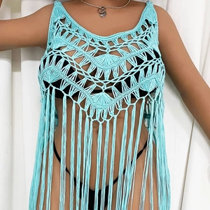 Detail of light blue crochet beach cover-up with intricate geometric knit and long tassels