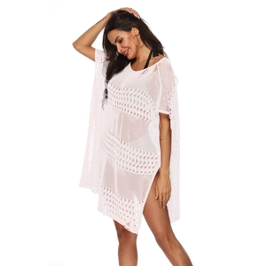 Détail de la robe de plage crochetée blanche avec motifs en losange et fentes latérales