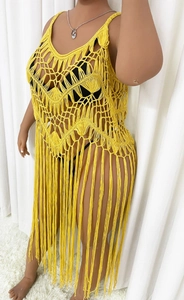 Detail of yellow crochet beach cover-up featuring geometric knit patterns and long tassels