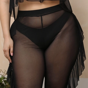 Detail of high waisted sheer mesh beach pants featuring elegant side ruffle trim in black