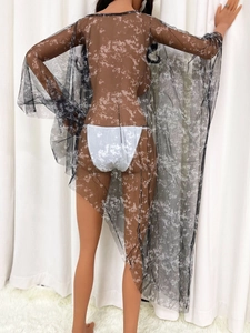 Détail de la tunique de plage en tulle noir transparent avec imprimé marbre et coupe asymétrique