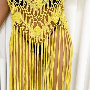 Detail of yellow macrame crochet beach cover-up featuring fringe and hollow weave