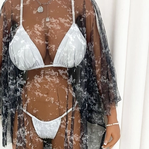 Détail du cache-maillot en résille transparente avec imprimé marbré et volants