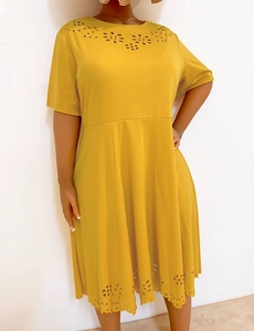 Detailed laser-cut floral patterns on a mustard yellow crew neck short sleeve dress