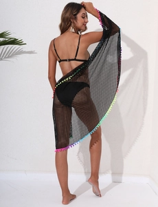 Détail du cache-maillot en maille noire avec pompons colorés et bikini sur modèle