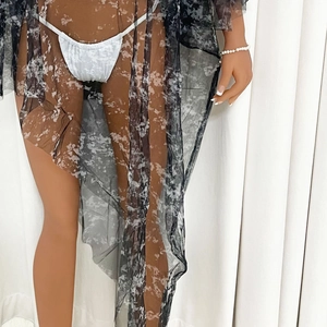 Détail de la tunique en tulle noir à motif marbre avec tissu fluide et bikini blanc élégant