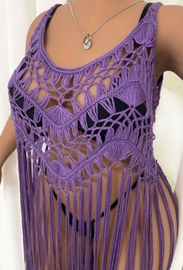 Detail of purple crochet beach cover-up featuring hollow patterns and long fringe tassels