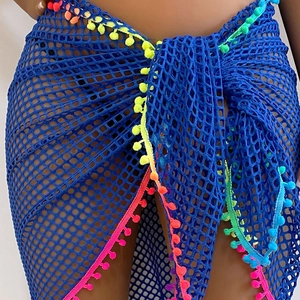 Detail of blue crochet mesh beach cover-up skirt with colorful pom-pom trim detail