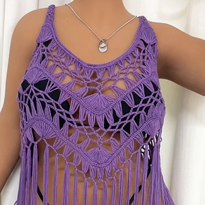 Detail of purple crochet hollow top with fine geometric patterns and long fringe hem