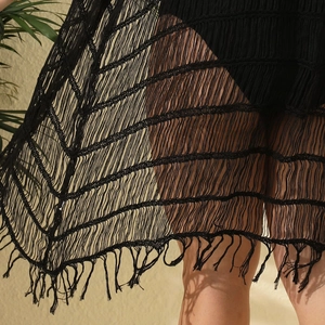 Nahaufnahme des schwarzen Strand-Cover-ups mit Netzstruktur und langen Fransen-Quasten