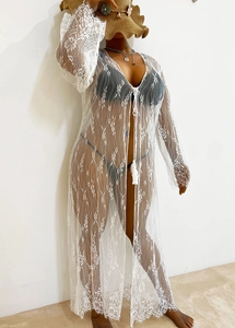 Détail d'un cache-maillot en dentelle blanche avec motifs floraux et manches cloche