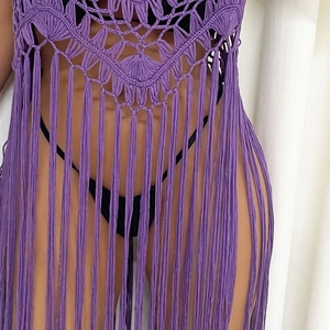 Detailed view of purple crochet pattern and long fringes on this bohemian beach cover-up