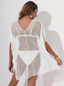 Macro detail of the white crochet knit mesh pattern on a loose beach cover-up dress