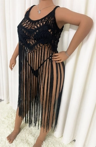 Detail of black crochet beach cover-up featuring geometric knit patterns and long tassels