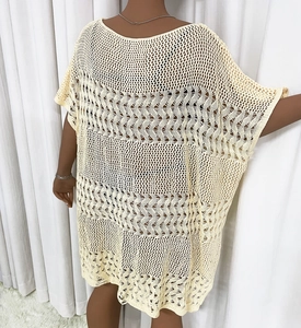 Détail d'une robe de plage en maille crochetée ajourée de couleur crème