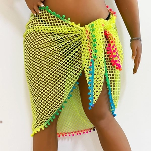 Close-up of neon yellow mesh beach sarong featuring vibrant multicolor pom-pom trim detail