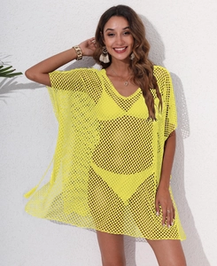 Detail of neon yellow crochet mesh beach cover-up with tassel ties and fringe texture
