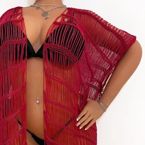 Detail eines roten Häkel-Strand-Cover-Ups mit Boho-Quasten und hohler Strickstruktur