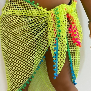 Detail showing the fluorescent mesh sarong with multi-colored pom-poms on the hem
