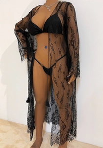Détail de la dentelle florale noire et de la bordure en cils sur ce long cache-maillot de plage