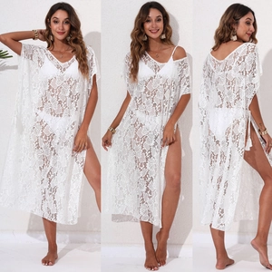 Detailed close-up of white floral lace beach cover-up with high side slits and V-neckline