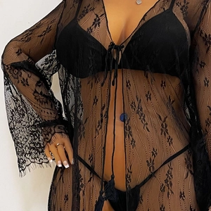 Détail d'un cardigan en dentelle noire transparente avec glands et ensemble bikini