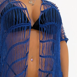 Nahaufnahme von hellblauem Häkel-Strand-Cover-up mit langen Fransen und Durchbruchmuster