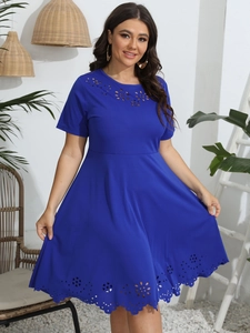 Close-up of royal blue dress featuring intricate laser-cut floral patterns on the hemline