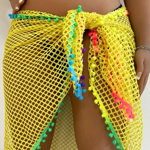 Close-up of yellow mesh beach sarong featuring colorful pom-poms and fringe details