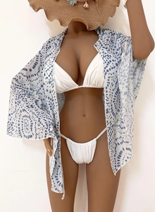 Three-piece beach set featuring white bikini with blue polka dot print wrap cover-up